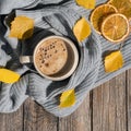 Autumn or Fall morning coffee. Fall yellow leaves, orange chips, hot steaming mug of coffee and a cozy grey sweater on Royalty Free Stock Photo