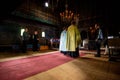 Sunday service in the orthodox old church in Roumania , priest giving blessing to old people