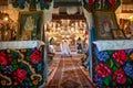 Sunday service in the orthodox traditional old church in Roumania , priest giving blessing to local people.