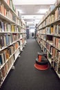 Books on library shelves with foot stool in between