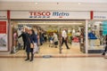 Entrance to Tesco Metro food and grocery supermarket showing sign, signage, logo and branding above door Royalty Free Stock Photo