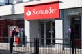 Exterior shot of Santander Bank Branch Building showing company name and logo with man at ATM Cashpoint Machine Royalty Free Stock Photo