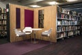 Seating area in modern library with books on shelves and seating area