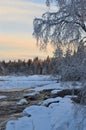 Frozen Kiiminki river and sunset on cold winter afternoon.