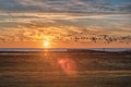 Sundown over the Baltic Sea at Bunkeflo Strandangar. A flock of sea birds is crossing the scene at sunset on the green reserve Royalty Free Stock Photo