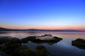 Sundown over the lake and big mossy stones in the water