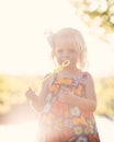 Sunflare caucasian girl playing at sunset with bubbles