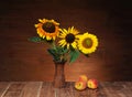 Sunflower in a ceramic vase and peaches on the table