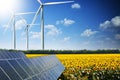 Sunflower field reflected on photovoltaic panels against wind turbines, concept of renewable energy from the nature Royalty Free Stock Photo