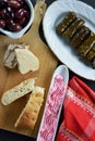 Sunflower halva and lagana bread on cutting board,olive dish with taramosalata,kalamon olives on bowl and stuffed grape leaves