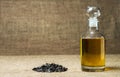 Sunflower oil in a glass decanter, a bunch of sunflower seeds on a background of burlap Royalty Free Stock Photo