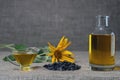 Sunflower oil in a glass gravy boat, in a bottle, and a handful of sunflower seeds