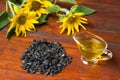 Sunflower oil in a glass gravy boat, and a handful of sunflower seeds on the background of sunflowers Royalty Free Stock Photo