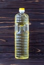 Sunflower oil in a plastic bottle on dark wooden boards, yellow salad-oil, transparent packaging. Healthy organic product. Food