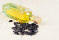 Sunflower seeds and a bottle of oil on wooden background.