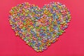 Sunflower seeds in colored glaze on a pink background laid out in the shape of a heart. Easter Royalty Free Stock Photo