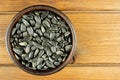 Sunflower seeds in the small bowl on the wooden background Royalty Free Stock Photo