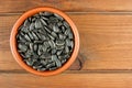 Sunflower seeds in the small bowl on the wooden background Royalty Free Stock Photo