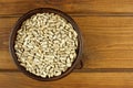 Sunflower seeds in the small bowl on the wooden background Royalty Free Stock Photo