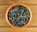 Sunflower seeds in the small bowl on the wooden background Royalty Free Stock Photo