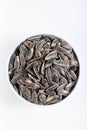 Sunflower seeds in white bowl on white background. Salted sunflower seeds in bowl. Royalty Free Stock Photo