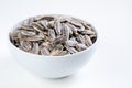 Sunflower seeds in white bowl on white background. Salted sunflower seeds in bowl. Close-up. Royalty Free Stock Photo