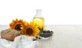 Sunflowers bottle of oil and seeds on wooden table against white background space for text