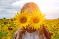 Sunflowers eyes. Adorable little girl holding Sunflowers in eyes like binoculars in the garden Royalty Free Stock Photo