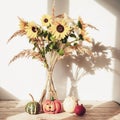 Sunflowers in glass vase with small decorative pumpkins against white wall in sunlight. Thanksgiving concept. Still life Royalty Free Stock Photo