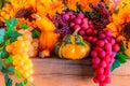 Sunflowers, grapes, and squash fill a decorated Thanksgiving mantel in the morning light