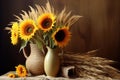 sunflowers in a vase next to harvested wheat sheaves