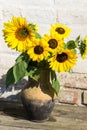 Sunflowers in vintage clay jug on wooden table Royalty Free Stock Photo