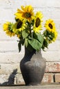 Sunflowers in vintage clay jug on wooden table Royalty Free Stock Photo