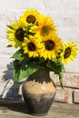 Sunflowers in vintage clay jug on wooden table Royalty Free Stock Photo