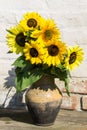 Sunflowers in vintage clay jug on wooden table Royalty Free Stock Photo