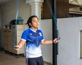 An athletic young man doing jumping rope exercise at home. Fitness, sports and healthy lifestyle concept