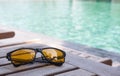 Sunglassed on wood table near swimming pool Royalty Free Stock Photo