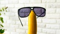 Sunglasses on a banana on a brick wall background,close-up.Cheerful fruit with glasses. Royalty Free Stock Photo