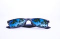 Sunglasses in a black frame with palm trees in the reflection of the lenses on a white background, isolated Royalty Free Stock Photo