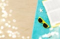 Sunglasses and book on beach towel on sand Royalty Free Stock Photo