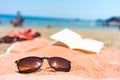 Sunglasses and book on a towel at the beach Royalty Free Stock Photo