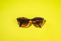 Sunglasses on a bright yellow background. Concept of weed summer, holiday and beach holidays. Minimalism, Flat lay
