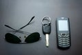 Sunglasses, car key and cellphone on a wooden table Royalty Free Stock Photo