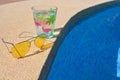 Sunglasses and cold drink on poolside, summer holiday concept Royalty Free Stock Photo