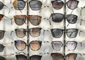 Sunglasses on display shelves in glasses store Royalty Free Stock Photo