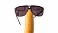 Sunglasses on a fruit head,isolated on white,funny banana with glasses,close-up. Royalty Free Stock Photo