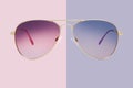 Sunglasses golden metallic frame and purple polarized lenses isolated on pink background