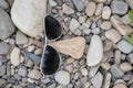 Sunglasses lie on white stones, symbolize the smiling face of a resting person.