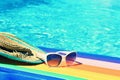 Sunglasses, lilo and hat on the water in hot sunny day. Summer background for traveling and vacation. Holiday idyllic. Royalty Free Stock Photo