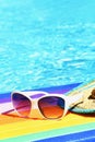 Sunglasses, lilo and hat on the water in hot sunny day. Summer background for traveling and vacation. Holiday idyllic. Royalty Free Stock Photo